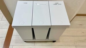A white, three-compartment, wheeled cart with a handle, likely used for cleaning or storage. - YMK Oshiage 3A (Tokyo)