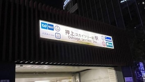A sign for Oshiage 'SKYTREE' Station with directions to Oishiage and Oishiage Station. - YMK Oshiage 7A (Tokyo)