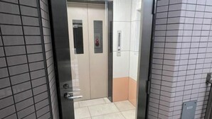 An elevator with a metallic door and a control panel. - YMK Oshiage 7A (Tokyo)