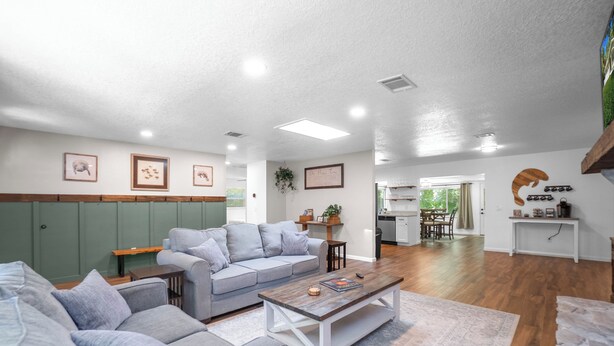 A modern living room with a grey sofa, a wooden coffee table, and a patterned rug. - Crystal River Getaway (Crystal River)