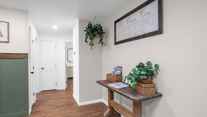 A hallway with a wooden bench, baskets, and hanging plants. - Crystal River Getaway (Crystal River)