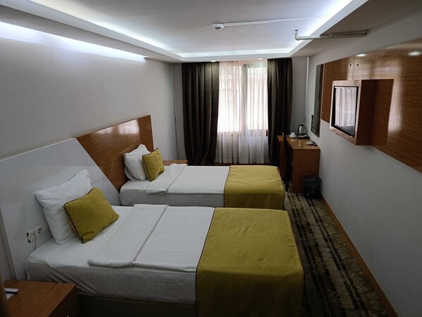 Habitación estándar con 1 cama matrimonial o 2 individuales | Escritorio, espacio para trabajar con laptop y cortinas blackout