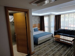 Suite estándar, 1 cama matrimonial, vista parcial al mar | Escritorio, espacio para trabajar con laptop y cortinas blackout