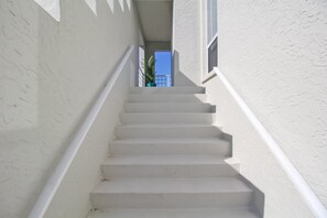 A white staircase with a handrail leading to a balcony. - Lakefront retreat - Minutes to Anna Maria Island - Driftwood Dreams (Bradenton)