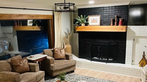 Una sala de estar con chimenea, sofás de cuero, una mesa de centro y una alfombra.