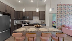 A modern kitchen with granite countertops, stainless steel appliances, and pendant lighting. - Tropical Haven 2BR/2BA Near Atlantic Beach (Jacksonville)
