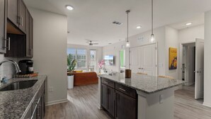A modern kitchen with granite countertops, dark cabinetry, and a central island. - Seaside Paradise 2BR/2BA Near Atlantic Beach (Jacksonville)