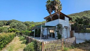 A two-story house with a patio and a covered outdoor seating area. - Duo of Mini-villas, cosy cottages with sea view (Olmeto)