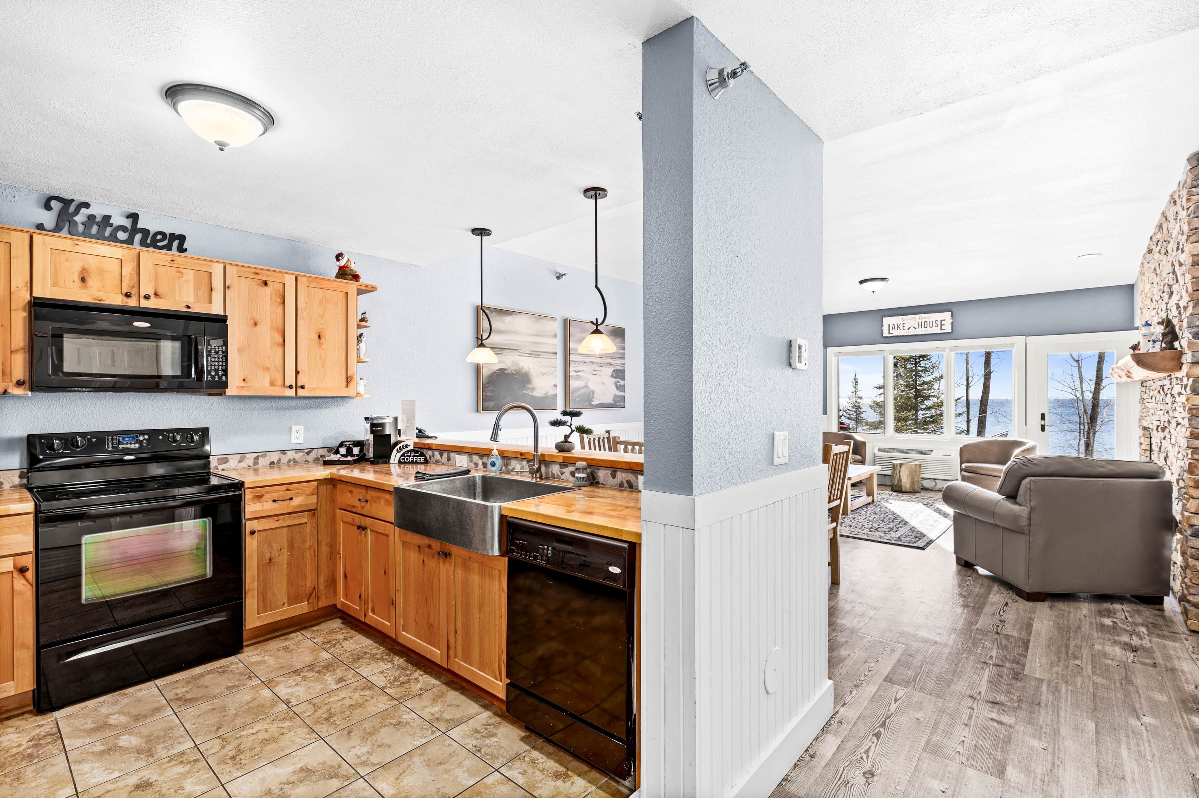 A modern kitchen with wooden cabinets, a black stove, and a dishwasher.