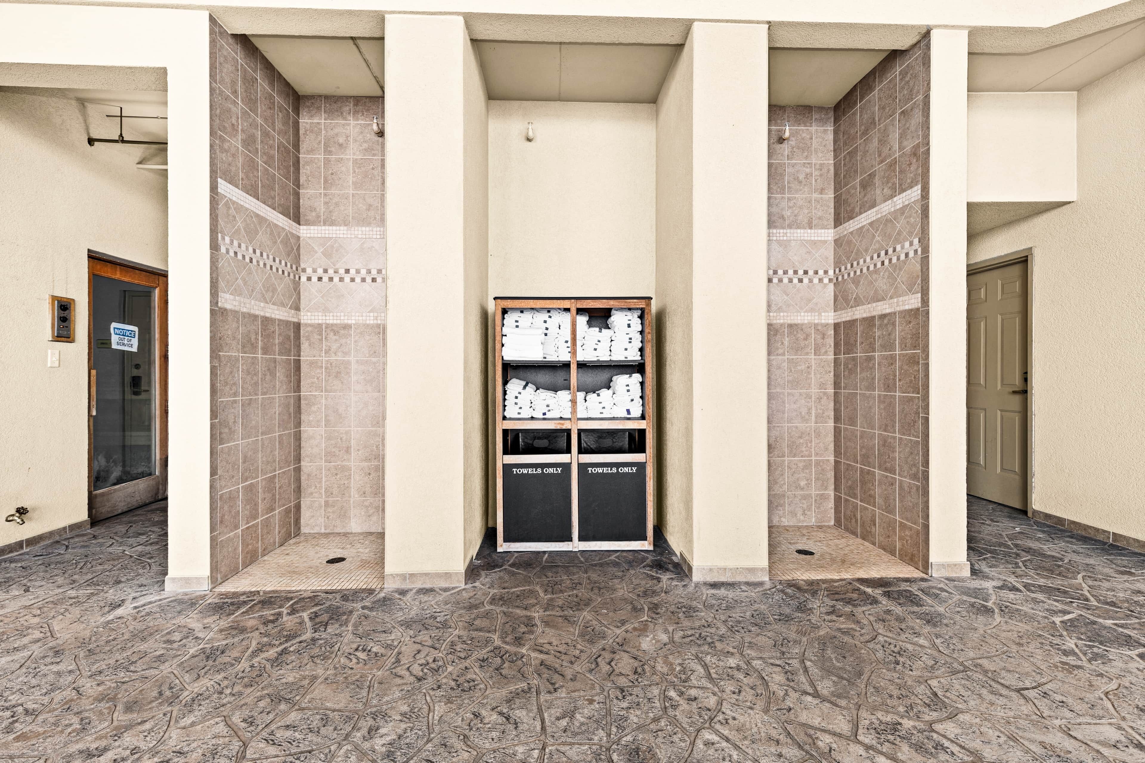 A hallway with a tiled floor and a storage unit labeled "TOWELS ONLY" in the center.