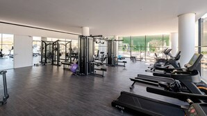 Ein modernes Fitnessstudio mit unterschiedlichen Trainingsgeräten, großen Fenstern und großzügigem Raumangebot.