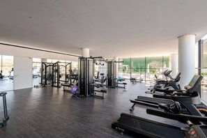 A modern gym with various exercise equipment, large windows, and a spacious layout. - Luxury San Jos Getaway Pool Gym Views (San José del Cabo)