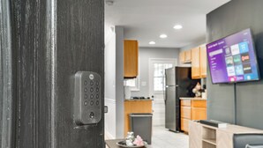 Eine moderne Küche mit Holzausstattung, einem Kühlschrank und einem Essbereich mit Tisch und Stühlen.