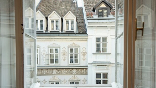 A view from a window overlooking a building with multiple windows and a staircase leading to an upper floor. - Cozy 1BR apartment near Opera - 24h self check-in (Wien)