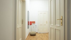 A hallway with white doors, a radiator, and two red emergency exit signs. - Cozy 1BR apartment near Opera - 24h self check-in (Wien)