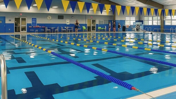 A large indoor swimming pool with multiple lanes, marked by blue and yellow lane dividers. - One-level Family Retreat I  Game Room I Bourbon Trail I King bed (Lebanon)