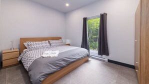 Una camera da letto moderna con un letto, un comodino e un armadio.