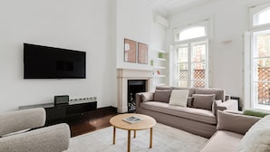 Una sala de estar con una televisión de pantalla plana, chimenea, sofá y mesa de centro.