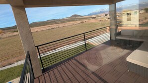 A balcony with a view of a grassy field and distant mountains. - Private Resort-Style Home, Near Zion Nat'l Park (Hurricane)