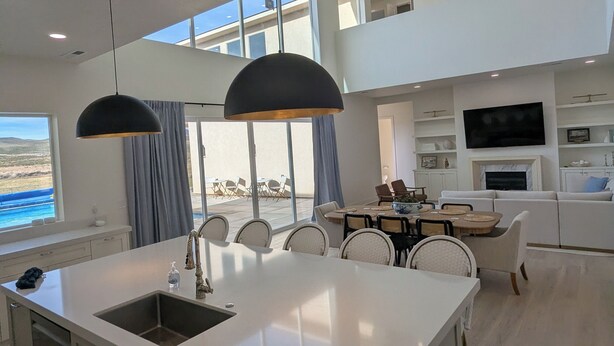 A modern kitchen with a central island, pendant lighting, and a view of the sea. - Private Resort-Style Home, Near Zion Nat'l Park (Hurricane)
