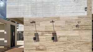 Un edificio moderno con fachada de piedra, dos fuentes y un estacionamiento.