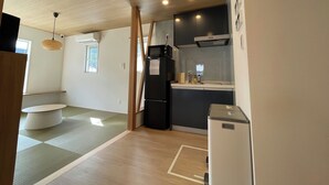 A compact kitchen with a microwave, refrigerator, and sink. There is a window providing natural light and a ceiling fan. - TINY HOTEL YADORIGI KAMIGOTO (Shinkamigoto)