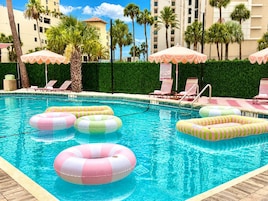 Una piscina al aire libre, sombrillas, sillones reclinables de piscina