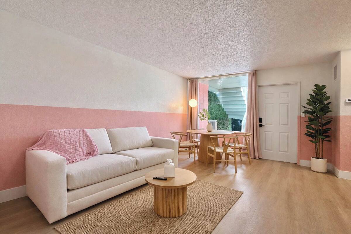 A modern living room with a sofa, a round coffee table, and a dining area with a table and chairs.