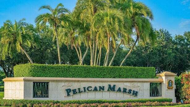 A sign for Pelican Marsh with a landscaped garden and palm trees in the background. - Welcome To Your Naples Escape, Perfectly Situated In One Of The Most Desirable Areas Of Town! (Naples)