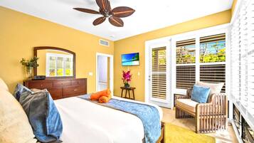 A bedroom with a bed, a dresser, a TV, a chair, and a balcony with blinds.