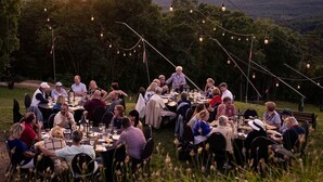 An outdoor dining area with multiple tables and chairs, surrounded by trees and a mountainous backdrop. - PINE PEAK COTTAGE: Quiet Luxury in the Mountains of Bryce Resort (Mount Jackson)