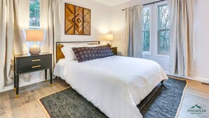 A bedroom with a bed, nightstands, a wall art piece, and a window with curtains. - PINE PEAK COTTAGE: Quiet Luxury in the Mountains of Bryce Resort (Mount Jackson)
