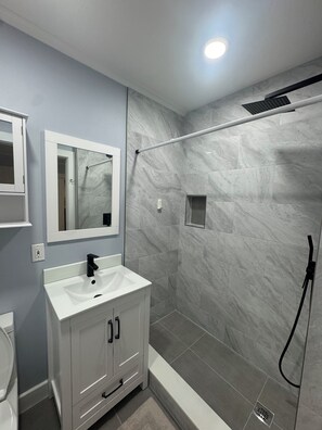 Regadera, secadora de cabello, toallas, papel de baño 