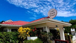A building with a red roof and a sign that reads "Ceiba Beach Resort". - Compass Rose House at Ceiba Beach Resort (Placencia)