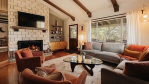 A living room with a fireplace, wooden beams, a sofa, armchairs, and a TV. - Three bedroom  in United States of America, Big Bear (Big Bear)
