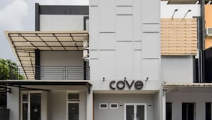 A modern building with a 'COVE' sign, a covered entrance, and a paved courtyard. - Cove Anasera (South Tangerang)