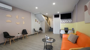 A modern interior with a reception area, seating, a staircase, and a visible 'cove' sign. - Cove Anasera (South Tangerang)