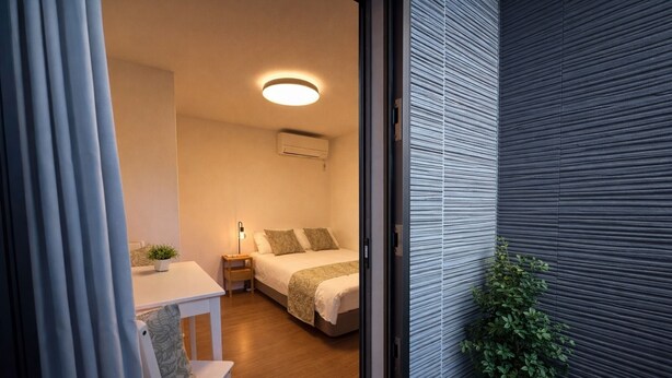A modern bedroom with a bed, bedside table, and a potted plant. - Yue Stay Komagome (Tokyo)