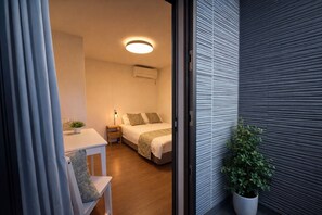Ein modernes Schlafzimmer mit Bett, Nachttisch und einer Topfpflanze.