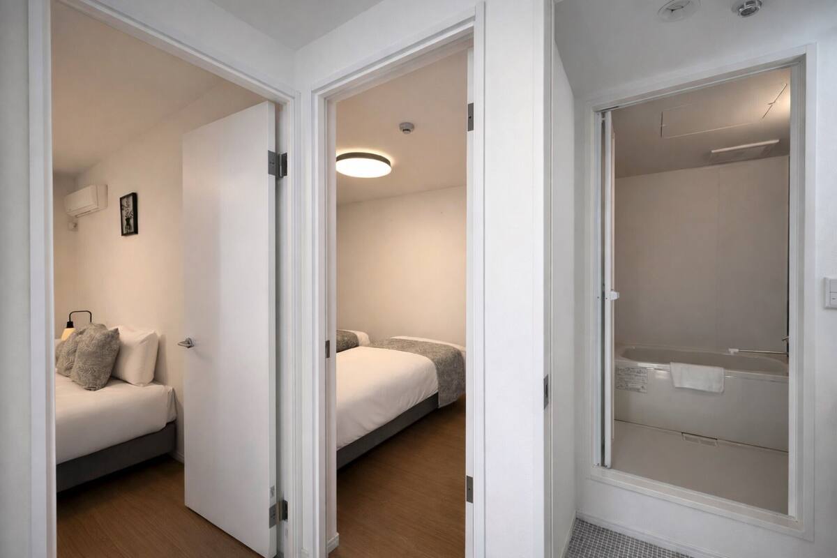 A hotel room with a bed, a bedside table, and a shower area.