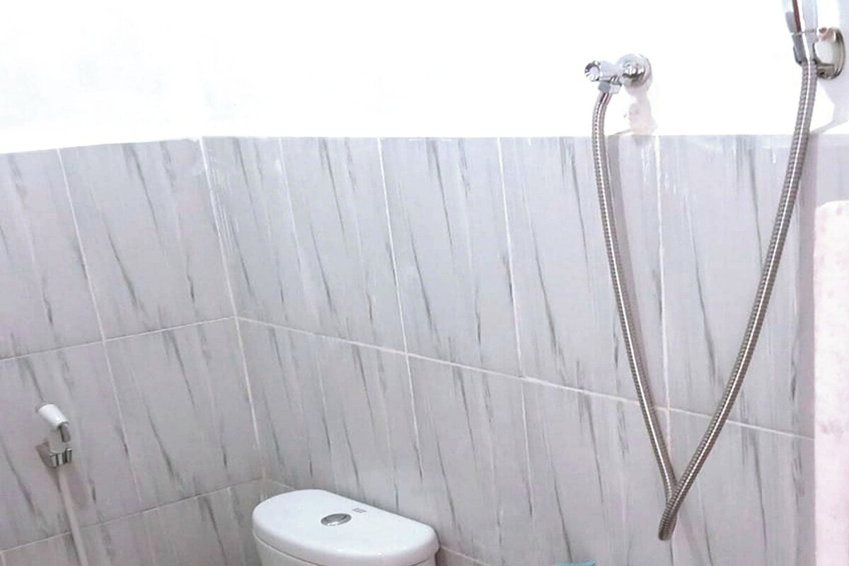 Un baño con inodoro, ducha y secamanos.
