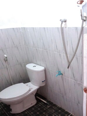 Un baño con inodoro, ducha y secamanos.