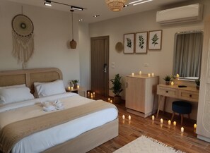A modern bedroom with a large bed, bedside tables with candles, a desk, and a wardrobe. - Zen Pyramids Luxury Villa (Giza)