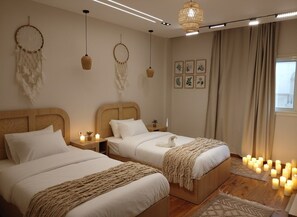 A bedroom with two beds, a large window, and decorative wall hangings. - Zen Pyramids Luxury Villa (Giza)