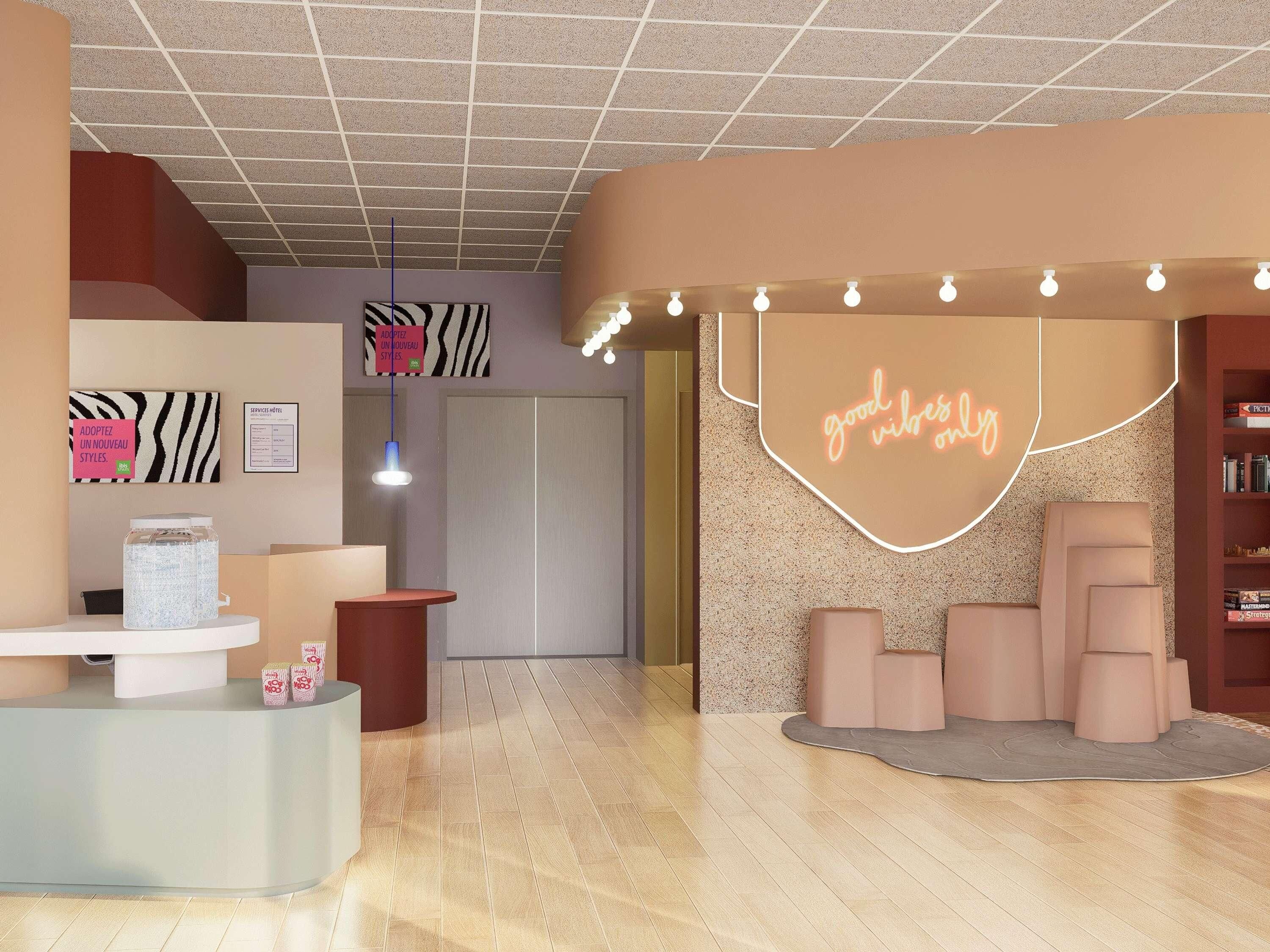 Eine moderne Hotelhalle mit einer Rezeption, einem leuchtenden Neon-Schild mit der Aufschrift "good vibes only" und einem Bücherregal voller Bücher.