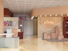 Un moderno vestíbulo de hotel con una recepción, un letrero de neón que dice 'good vibes only' y una estantería llena de libros.