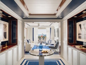 A hotel lobby with a round table, seating area with chairs, and a view of the ocean. - MIM Sotogrande Member of Meliá Collection (Cadiz)