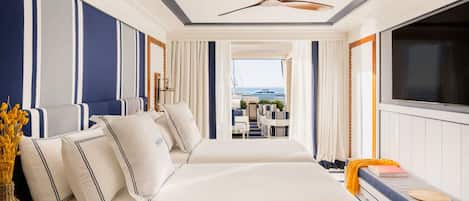 Ein geräumiges Schlafzimmer mit einem großen Bett, einem Fernseher und Blick auf den Balkon.