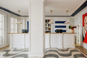 A modern kitchen with white cabinetry, a wooden countertop, and pendant lighting. - MIM Sotogrande Member of Meliá Collection (Cadiz)