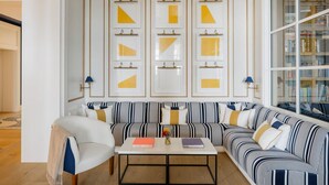 Una sala de estar moderna con un sofá a rayas, una mesa de centro con libros y una estantería llena de libros.